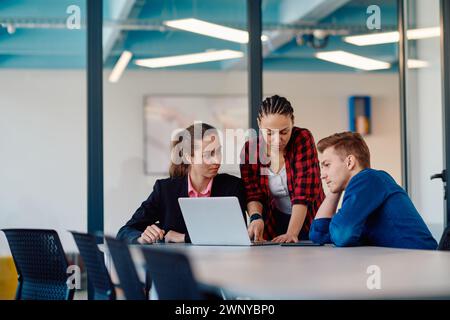 A team of successful programmers sits in a startup office, strategizing new business projects and solving existing challenges, showcasing innovation Stock Photo