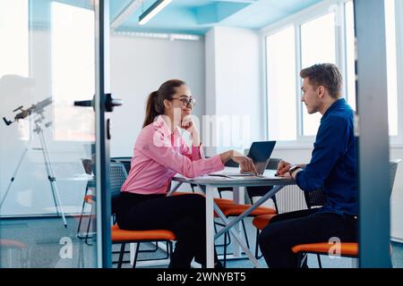 In a sleek, modern glass office, the director engages in a productive discussion with an employee, focusing on business projects and fostering Stock Photo