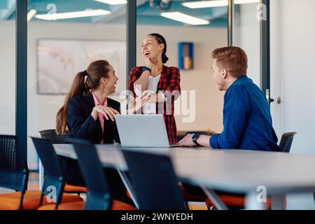 A team of successful programmers sits in a startup office, strategizing new business projects and solving existing challenges, showcasing innovation Stock Photo