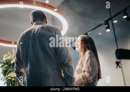 Two businesspeople discussing work outcomes and analyzing better efficiency in a corporate environment. Stock Photo