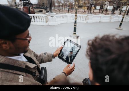 Two young entrepreneurs engaging with a tablet in an urban setting, reflecting the modern business lifestyle and mobile technology usage. Stock Photo