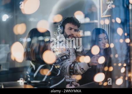 Focused young creative people engaged in collaborative work late at night. Stock Photo