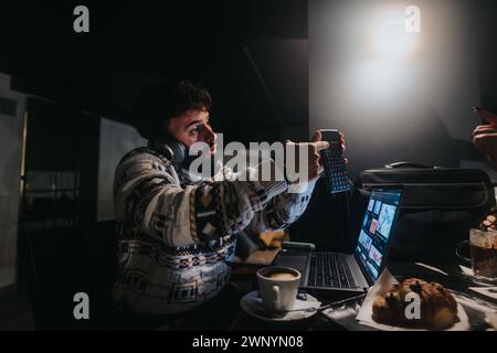 Focused creative professional editing video at night in cozy office space. Stock Photo