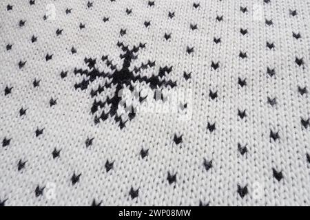 Jacquard knitted pattern. Geometric ornament for Christmas or New Year. Knitted black snowflakes and dots on a white background. Winter trendy modern Stock Photo