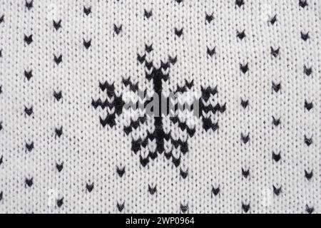 Jacquard knitted pattern. Geometric ornament for Christmas or New Year. Knitted black snowflakes and dots on a white background. Winter trendy modern Stock Photo