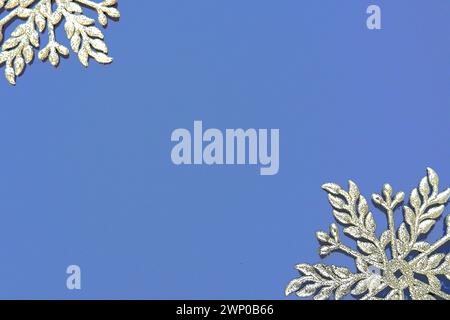 Christmas background with snowflakes. On a blue background two silver-white snowflakes with sparkles are laid out. Happy New Year. Merry Christmas Stock Photo