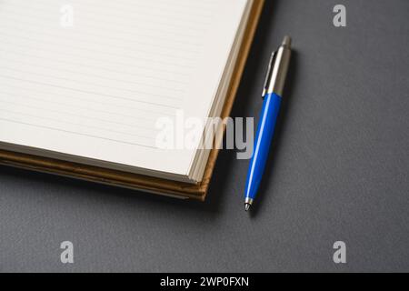 Ballpoint pen made of blue plastic and metal standing on lined notebook Stock Photo