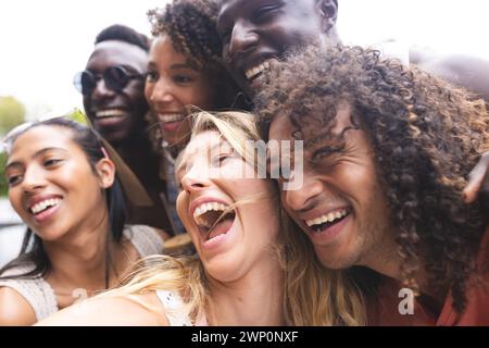 Diverse group of friends share a joyful moment, laughing together outdoors Stock Photo