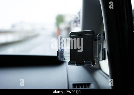 Smartphone car holder installed on the dashboard of a car. Stock Photo