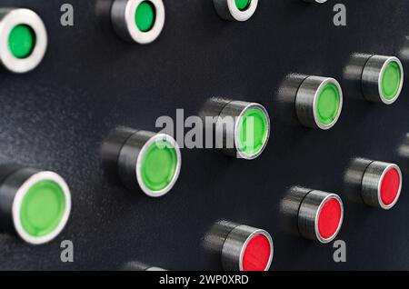 Black control panel with red and green round lamps and buttons. Abstract industrial background. Stock Photo