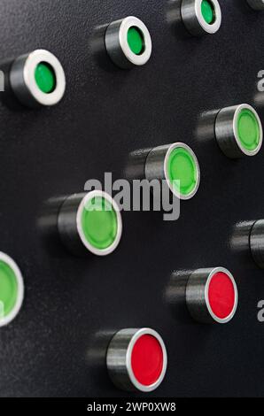 Black control panel with red and green round lamps and buttons. Abstract industrial background. Stock Photo