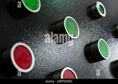 Black control panel with red and green round lamps and buttons. Abstract industrial background. Stock Photo