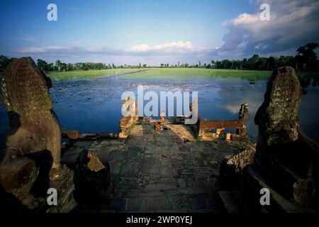 Boys playing on ruins at lake edge, Sra Srang, Angkor Wat complex, Siem Riep, Cambodia Stock Photo