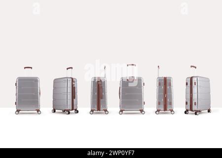Gray plastic suitcase isolated on white background, group of vacation luggage in perspective view Stock Photo