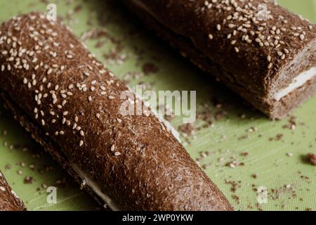 Closeup of delicious fresh sprinkled multigrain baked cheese bread cut into pieces and placed on wooden surface in room during daytime Stock Photo
