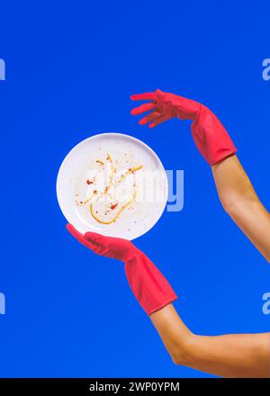 Red Rubber Gloves with a Dirty Dish Stock Photo