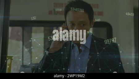 Image of network of connections and numbers over asian businessman talking on smartphone Stock Photo