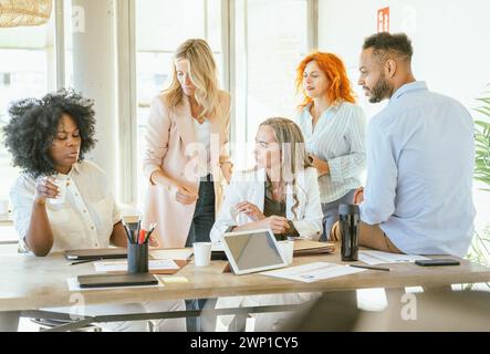 Businesswoman talking to her colleagues while gathering in the meeting room. Business concept. Stock Photo