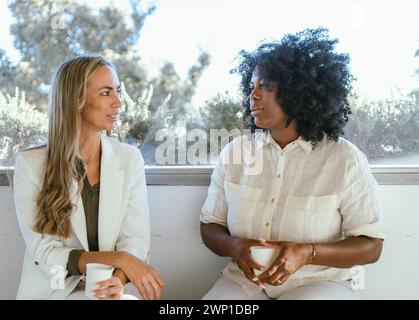 Coworkers chatting and relaxing while having coffee break in the office. Business concept. Stock Photo