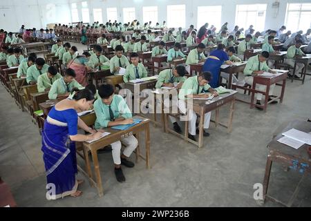 Students are seen writing an English paper. This is the first exam for the higher secondary (Class 12) board exam organized by TBSE (Tripura Board of Secondary Education) in Agartala. Tripura, India. Stock Photo