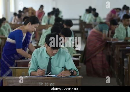 Students are seen writing an English paper. This is the first exam for the higher secondary (Class 12) board exam organized by TBSE (Tripura Board of Secondary Education) in Agartala. Tripura, India. Stock Photo