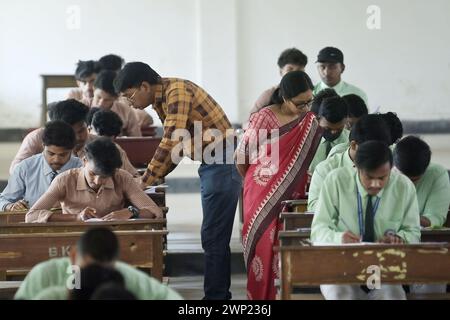 Students are seen writing an English paper. This is the first exam for the higher secondary (Class 12) board exam organized by TBSE (Tripura Board of Secondary Education) in Agartala. Tripura, India. Stock Photo