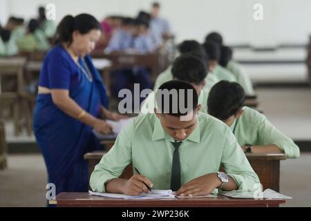 Students are seen writing an English paper. This is the first exam for the higher secondary (Class 12) board exam organized by TBSE (Tripura Board of Secondary Education) in Agartala. Tripura, India. Stock Photo