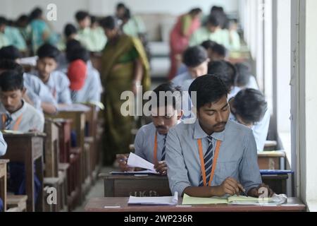 Students are seen writing an English paper. This is the first exam for the higher secondary (Class 12) board exam organized by TBSE (Tripura Board of Secondary Education) in Agartala. Tripura, India. Stock Photo