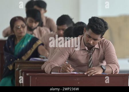 Students are seen writing an English paper. This is the first exam for the higher secondary (Class 12) board exam organized by TBSE (Tripura Board of Secondary Education) in Agartala. Tripura, India. Stock Photo