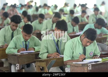 Students are seen writing an English paper. This is the first exam for the higher secondary (Class 12) board exam organized by TBSE (Tripura Board of Secondary Education) in Agartala. Tripura, India. Stock Photo