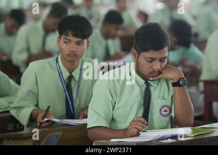 Students are seen writing an English paper. This is the first exam for the higher secondary (Class 12) board exam organized by TBSE (Tripura Board of Secondary Education) in Agartala. Tripura, India. Stock Photo