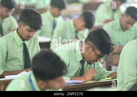 Students are seen writing an English paper. This is the first exam for the higher secondary (Class 12) board exam organized by TBSE (Tripura Board of Secondary Education) in Agartala. Tripura, India. Stock Photo