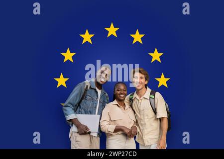 Three smiling students with backpacks and a laptop standing together Stock Photo