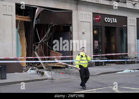 Hackney Riot Bus A police officer stands near a bus with a smashed window in Hackney ...