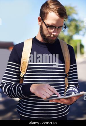 Man, tablet and scroll online while outdoor, taxi service app or rideshare for travel and connection in street. Touchscreen, tech and social media Stock Photo