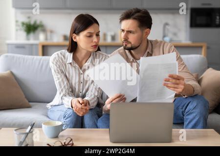 Young couple reviewing documents with concern Stock Photo