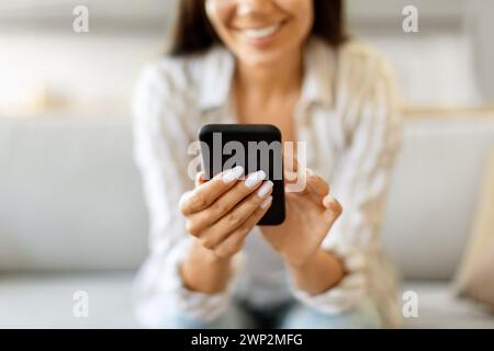 Shopping Online. Young Smiling Lady Using Smartphone At Home Stock Photo