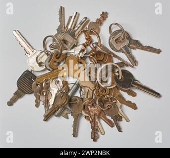bunch of keys, different types of used metallic house keys isolated on neutral gray background, taken straight from above Stock Photo
