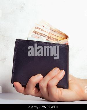 close-up of the purse in the hand, in the purse there is cash Russian money - rubles in denomination of five thousand Russian rubles, side view Stock Photo