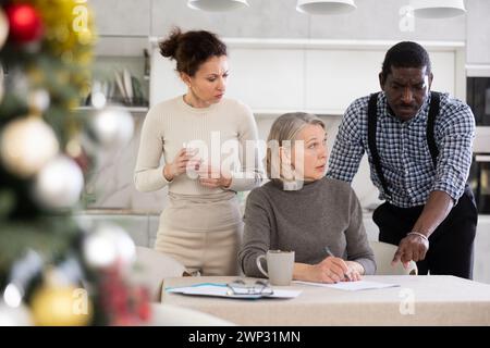 Couple discussing testament with elderly woman Stock Photo