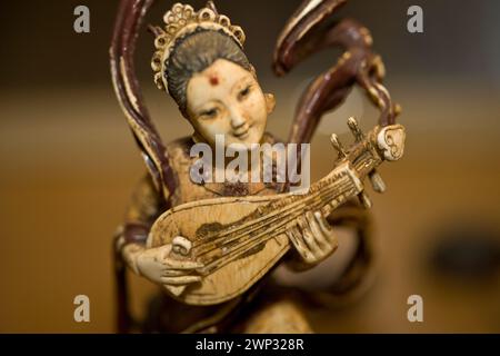 Carved ivory figurine, woman playing a pipa, traditional Chinese lute Stock Photo