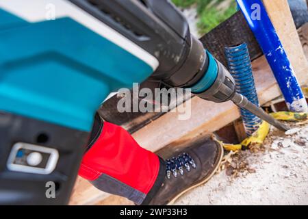 Concrete Drilling and Crashing Using Battery Operated Cordless Drill Driver Stock Photo