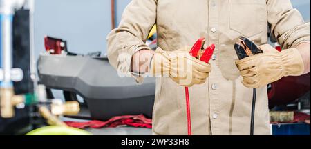 Professional Vehicles Mechanic with a Car Jumping Cables in His Hands Stock Photo