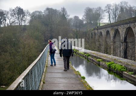 An older couple walking on the towpath beside the  Llangollen Canal as it flows across the Chirck Aqueduct on the English Welsh border. Stock Photo