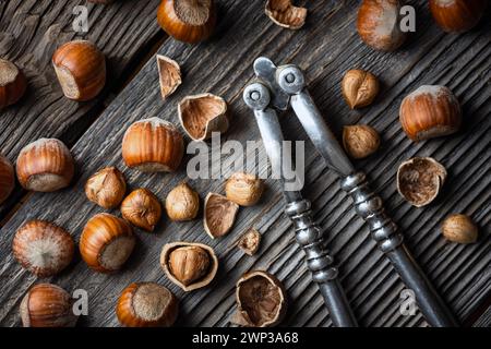 Hazelnuts with a classic silver nutcracker on wooden table. Food photography Stock Photo
