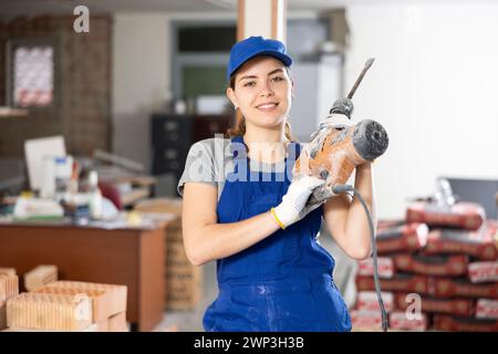 Portrait of woman engineer holding electric hammer Stock Photo