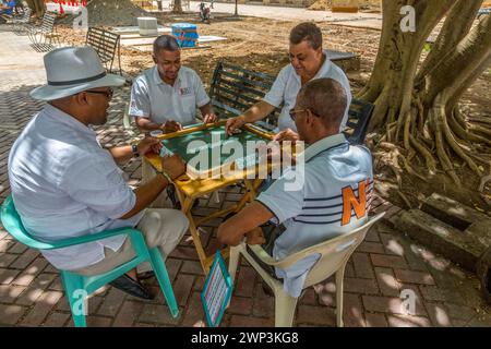 Dominican men playing dominoes on the Columbus Plaza in the old Colonial City of Santo Domingo, Dominican Republic.  Dominos is the unofficial nationa Stock Photo