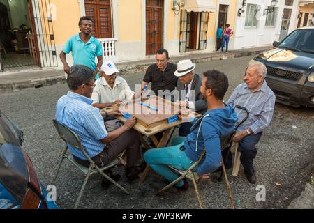 Dominican men playing dominoes on the in the street in the old Colonial City of Santo Domingo, Dominican Republic.  Dominos is the unofficial national Stock Photo