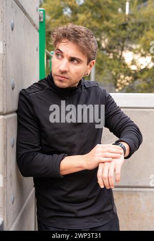 Vertical portrait sportsman looking at smartwatch with blank screen outdoors. Stock Photo