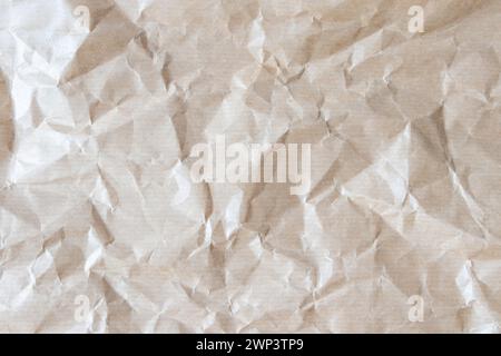 Wrinkled recycled brown wrapping paper background. Crumpled striped paper texture. Grunge backdrop. Stock Photo